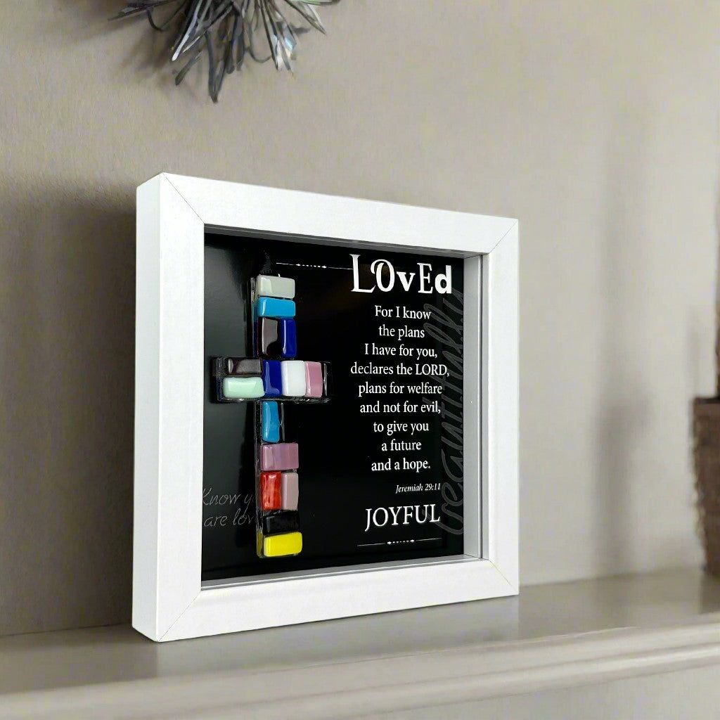 Side view of Loved shadowbox frame shown standing up straight on a fireplace mantle