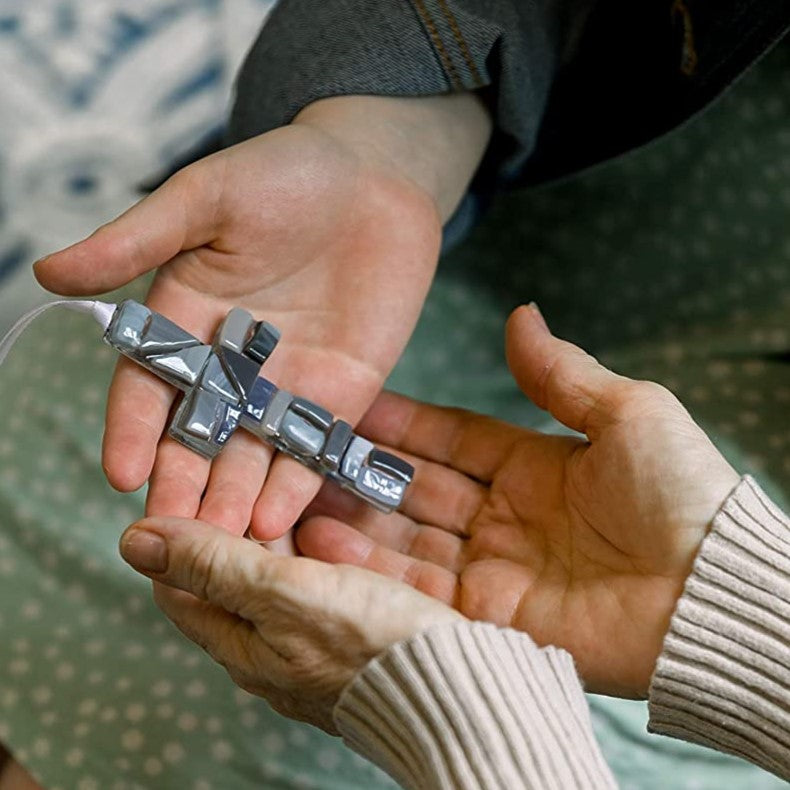 Hands exchanging a gray mosaic cross.