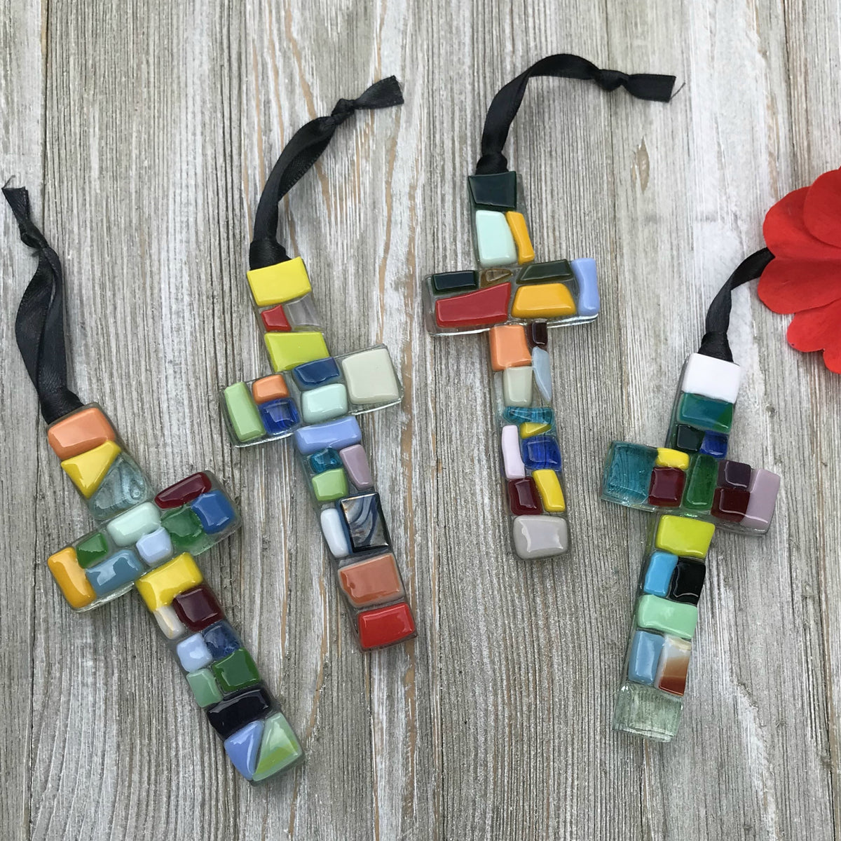 An assortment of colorful mosaic glass crosses.