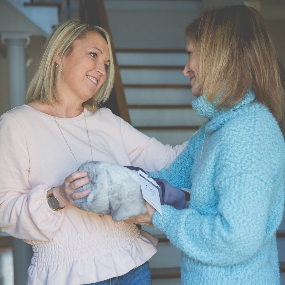 Two women exchanging the comfort blanket.